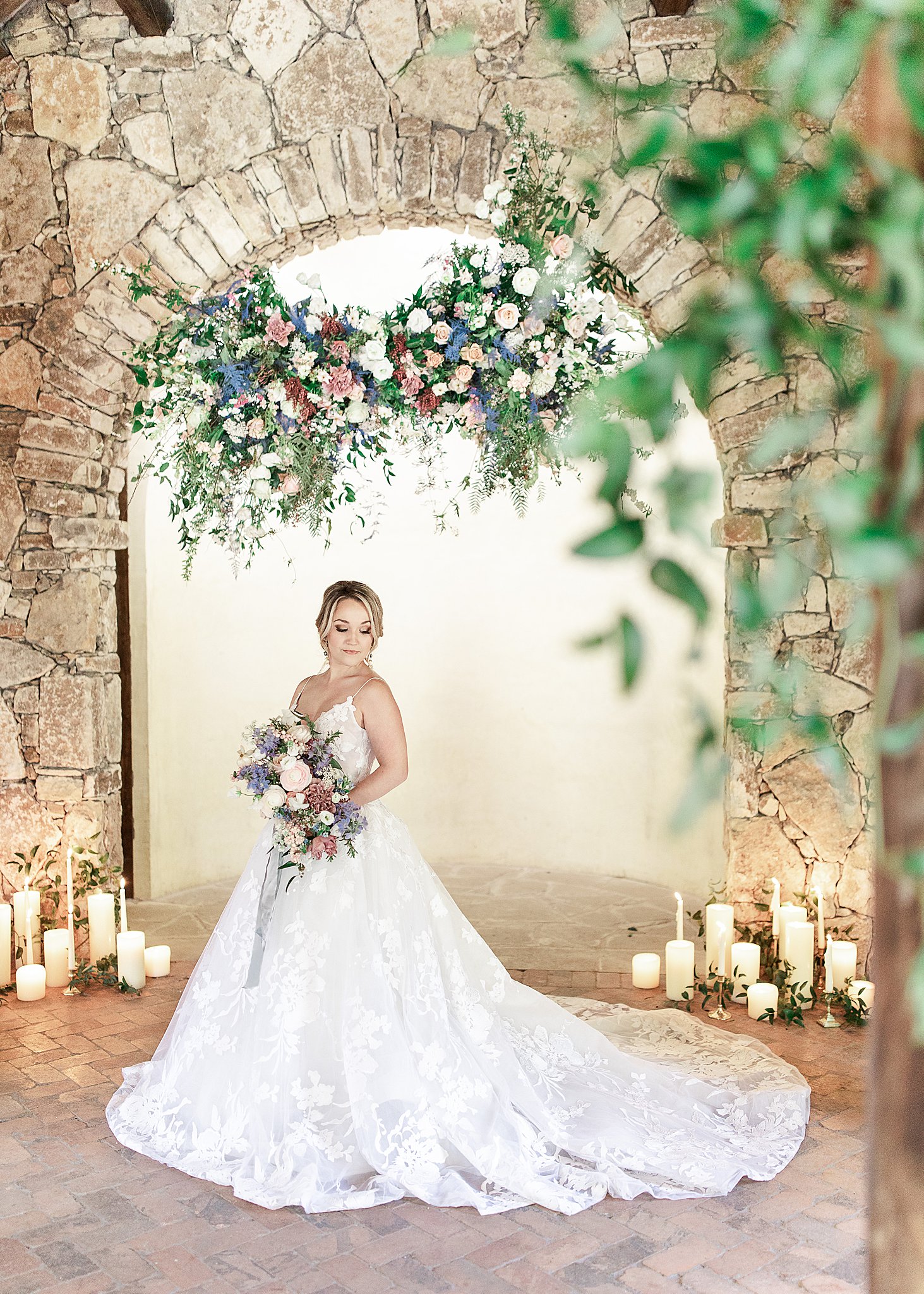 monique lhuillier bridal gown at Ian's Chapel at Camp Lucy archway with gorgeous floral installation